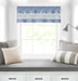 Light blue window curtain valance with geometric pattern on a white window, styled above a cozy window seat with cushions.