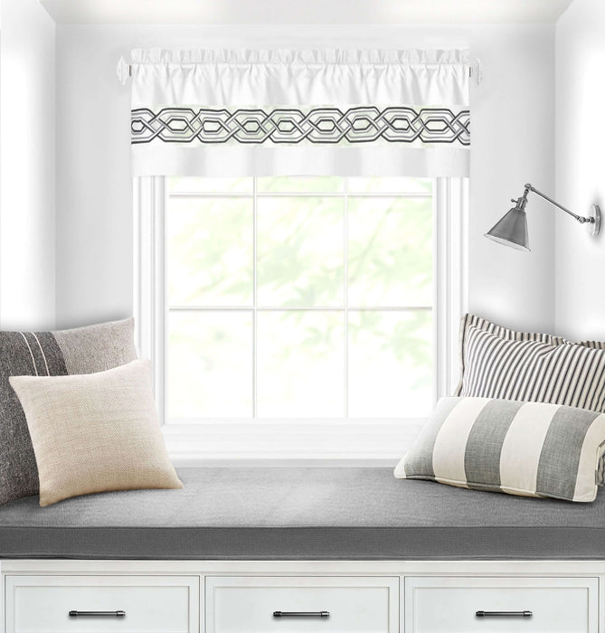 White window curtain valance 55x13 with geometric pattern 1.5-inch rod pocket above cozy window seat with pillows.